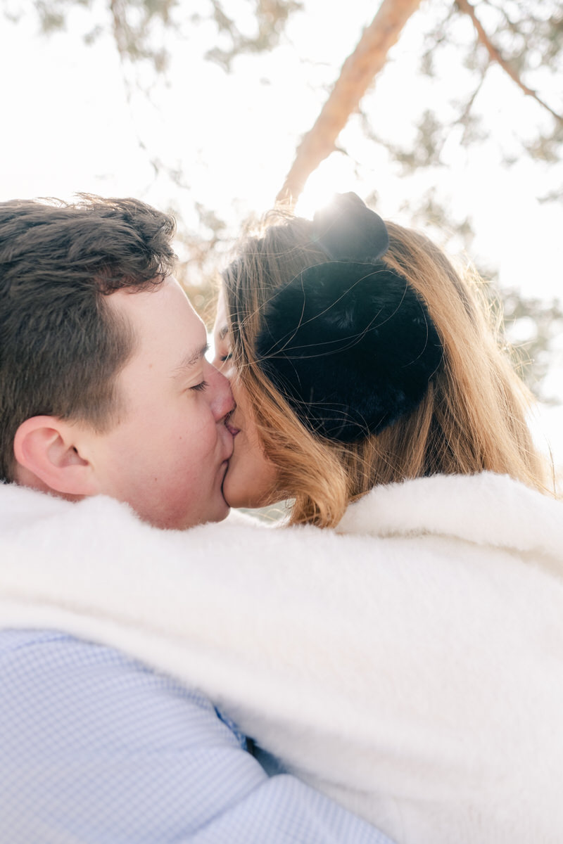 boy and girl kissing with female wearing ear muffs