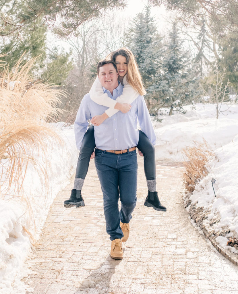 man carries fiance piggyback during their Chicago Engagement photos