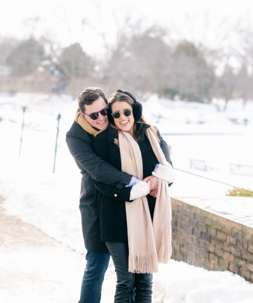Couple poses in winter coats in snow