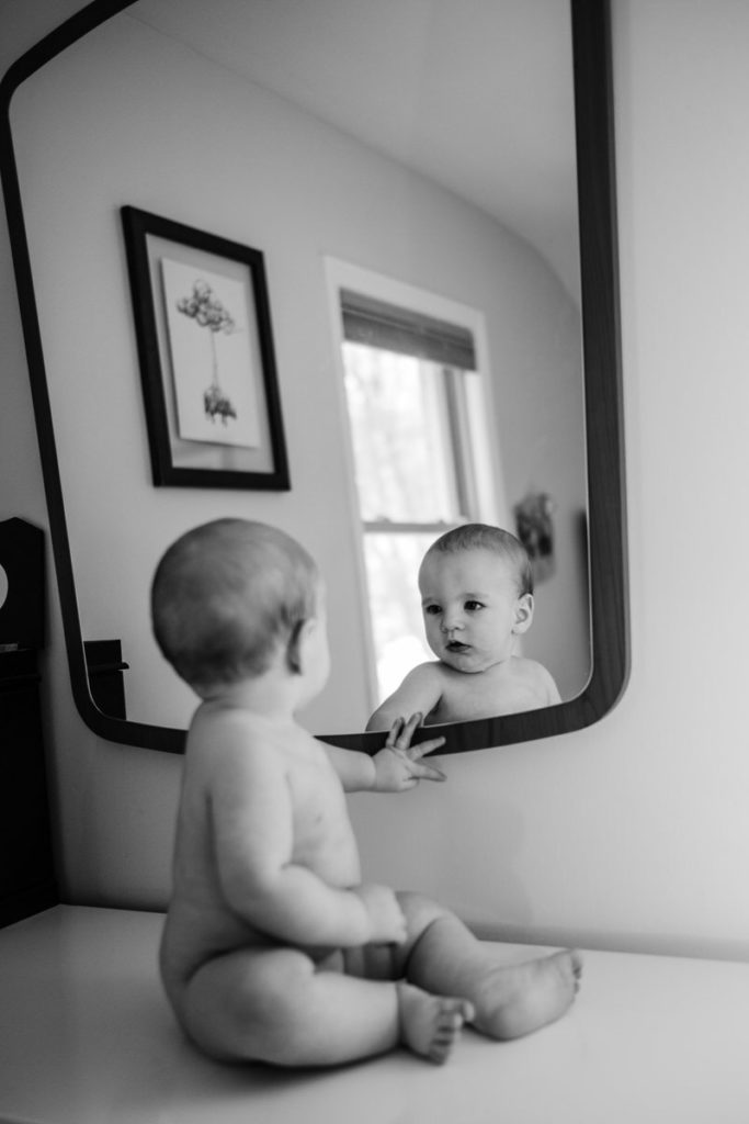 baby looking at himself in mirror