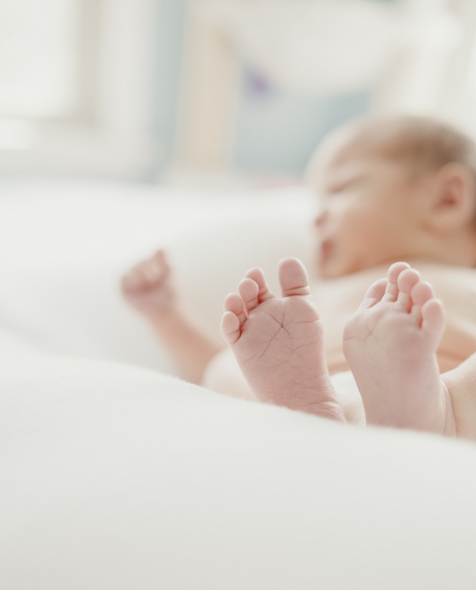 newborn baby laying on bed during Evanston Newborn Photography session