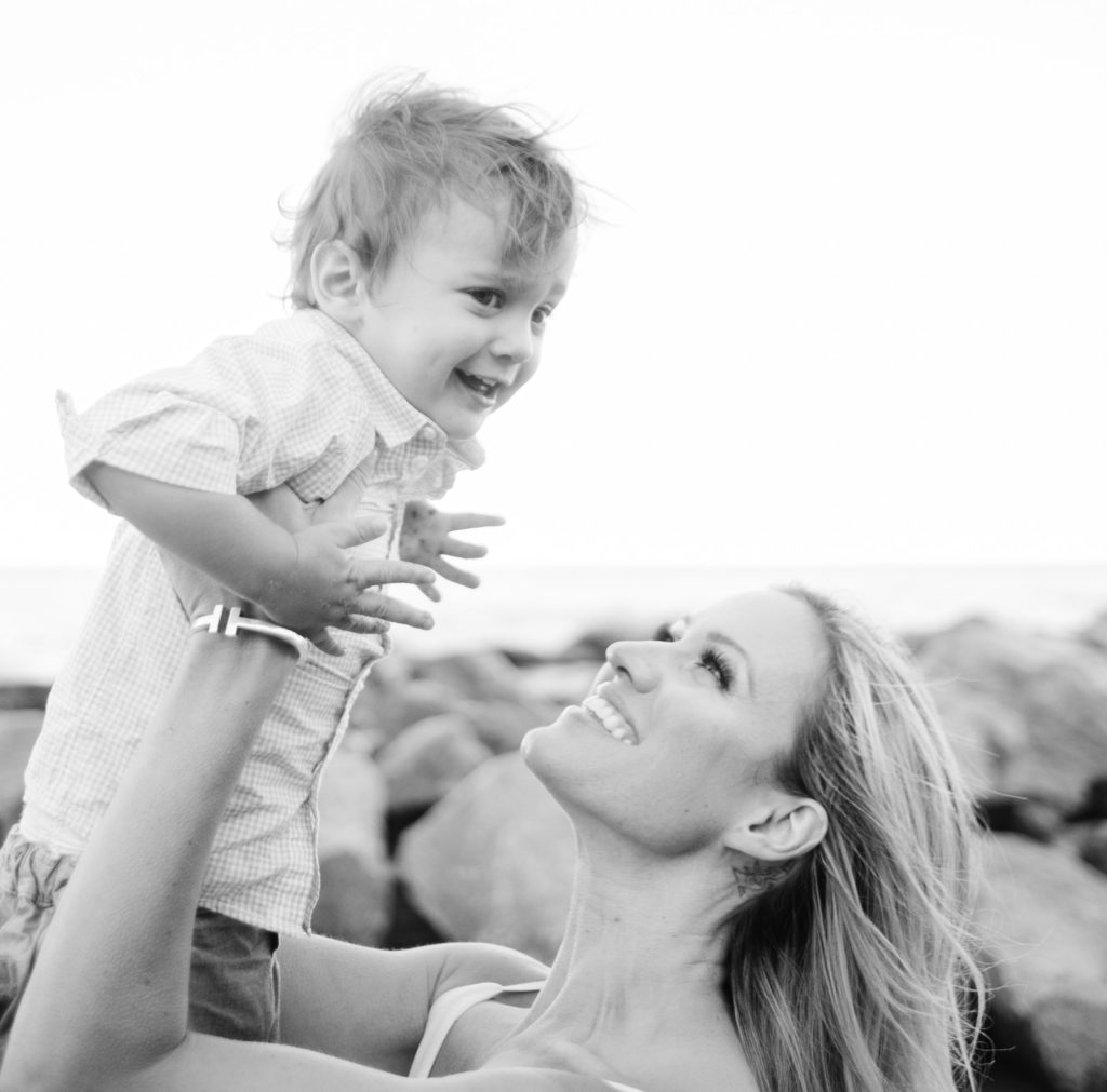 a mom lifts her son into the air during their glenview family photo session