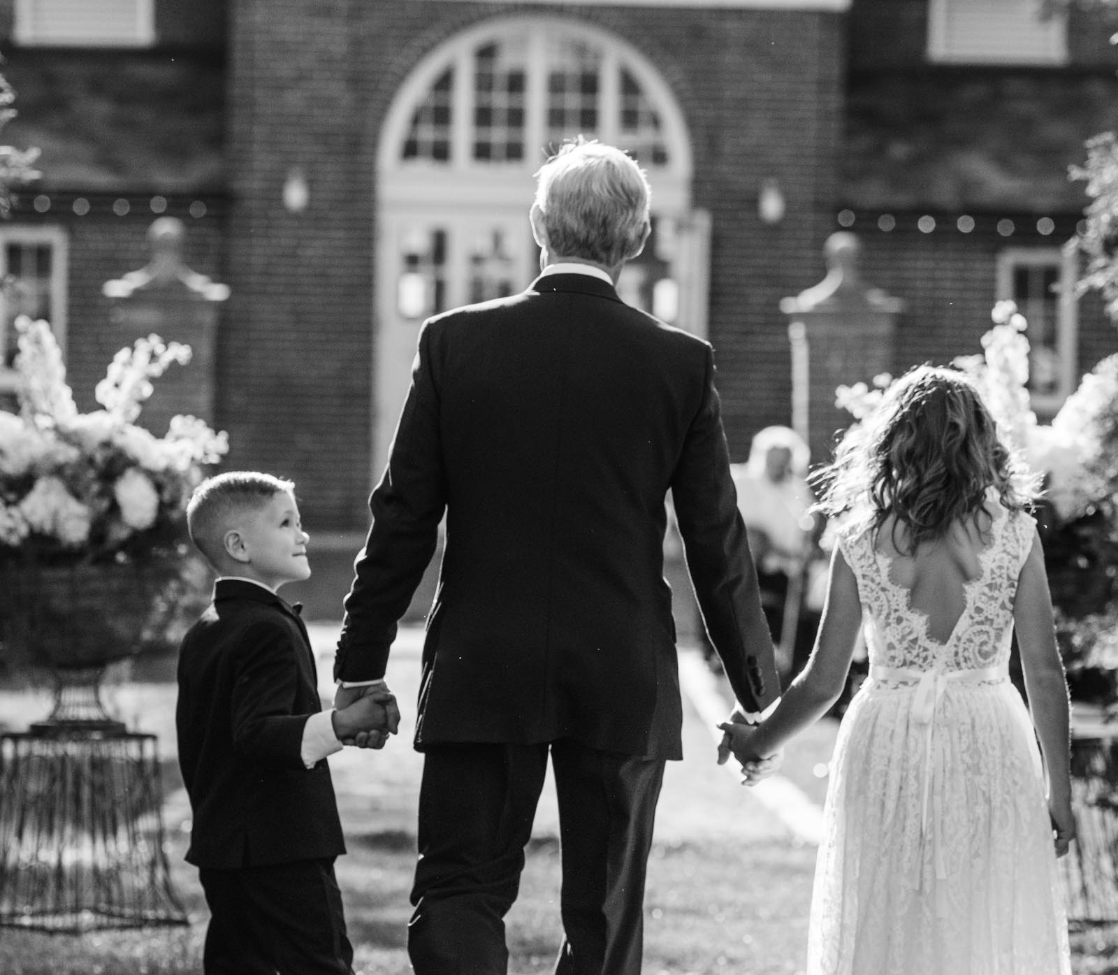 a groom being escorted down the aisle by his grandchildren