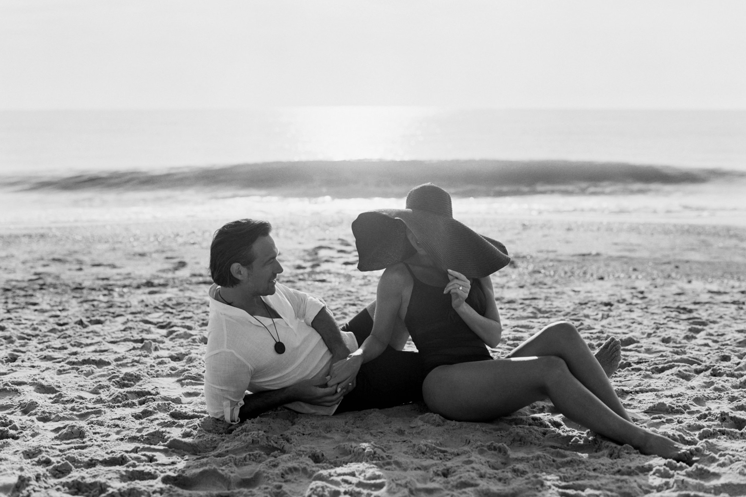 A man and woman laying on the beach together