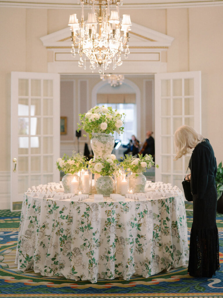 A woman looks for her seating table number at a well adorned wedding seat card display